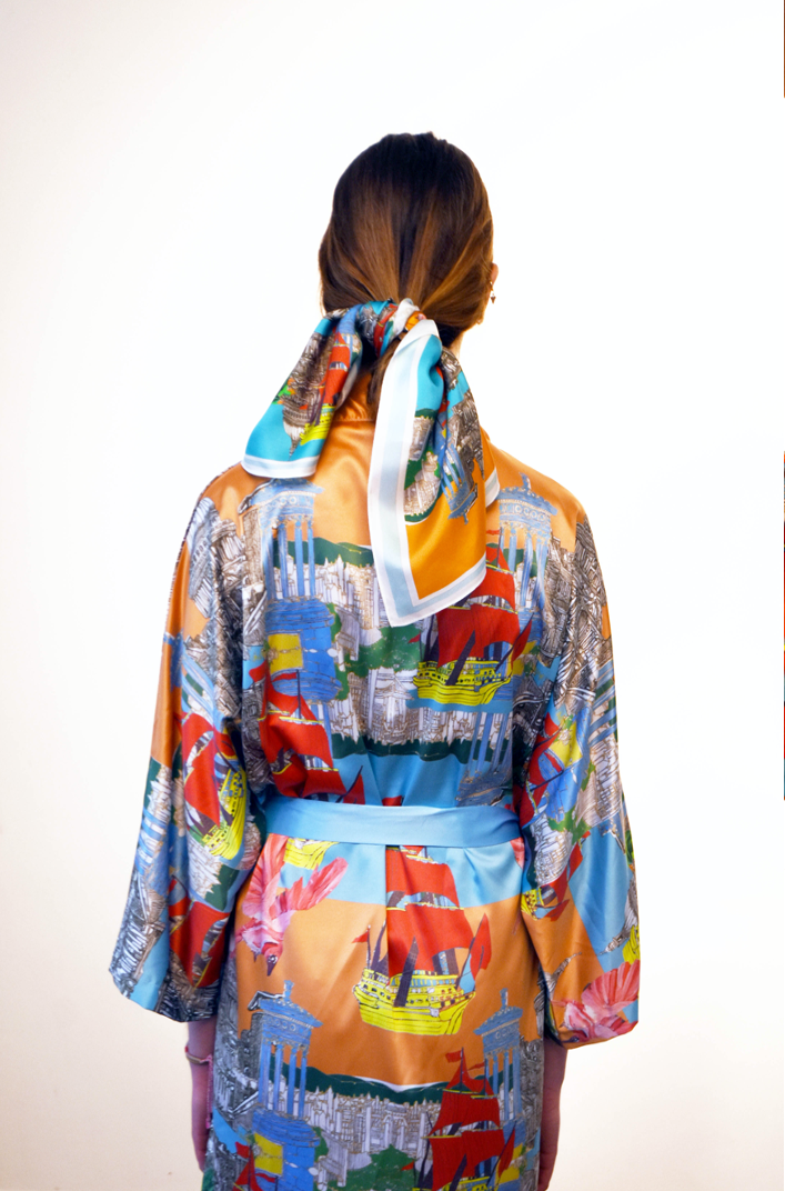 Back view of a model wearing a colourful patterned silk robe with a matching scarf tied in their hair